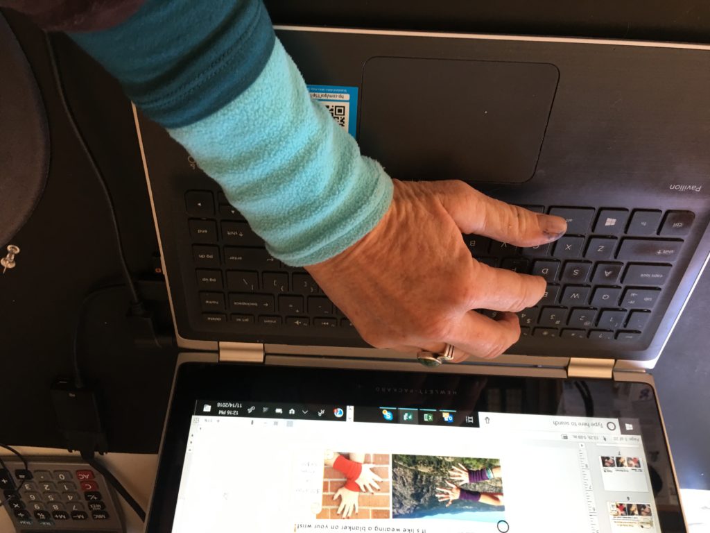 thermal layer wrist warmers hand with blue wrist warmer using computer